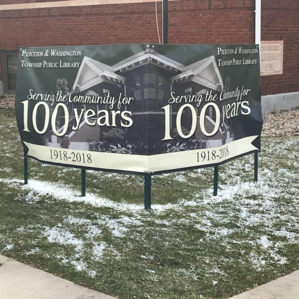 banner in the grass in front of the library building saying "100 years" to celebrate the 100 year anniversary of the library