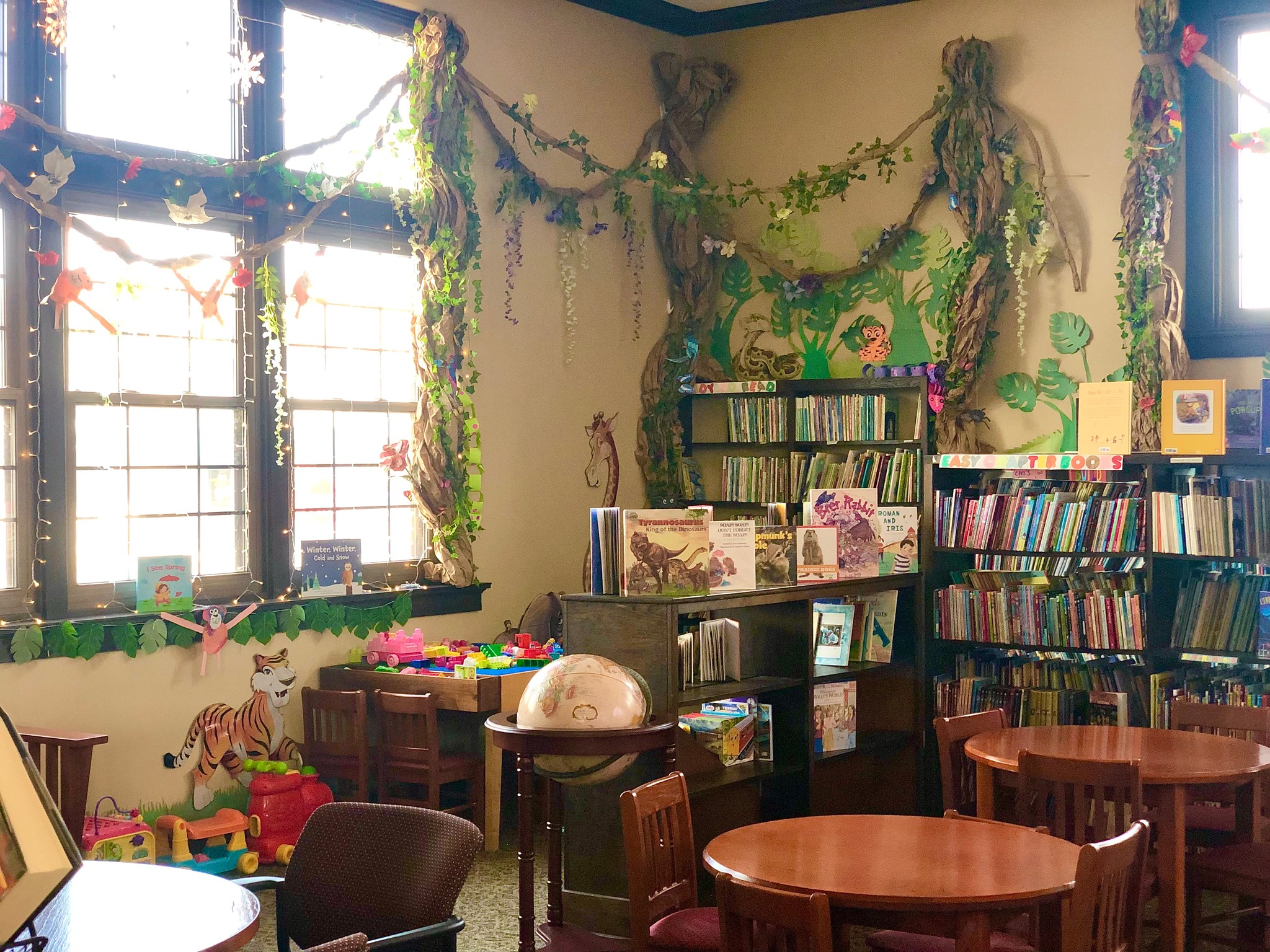 children's section of the library, indoors, decorated with paper vines and trees to resemble a jungle